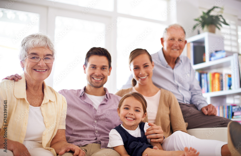 Fototapeta premium Portrait, big family and happy child on sofa in home for bonding, love or kid relax together with parents. Face, grandparents and girl with mother and father in living room with smile for connection