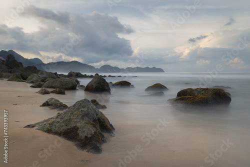 Landscape photograph of a white sand beach and rugged rocky coastline of tropical Sumatra island in Aceh district,  Lhoknga beach photo