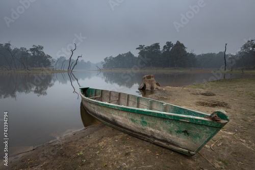 Old boat at the shore of a lake in Chitwan National Park buffer zone called 'Twenty thousand islands'.