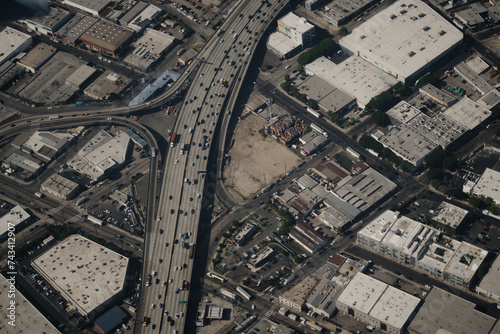 The 10 Freeway cuts through the Fashion District of Los Angeles, near the Alameda St exit. The aerial view shows the "car culture" of Southern California: hundreds of cars drive across fourteen lanes.