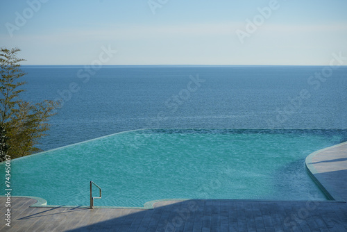 Private Swimming Pool with perspective view on sea. empty pool with blue clear pure water of luxury suite overlooking beach at tropical resort.