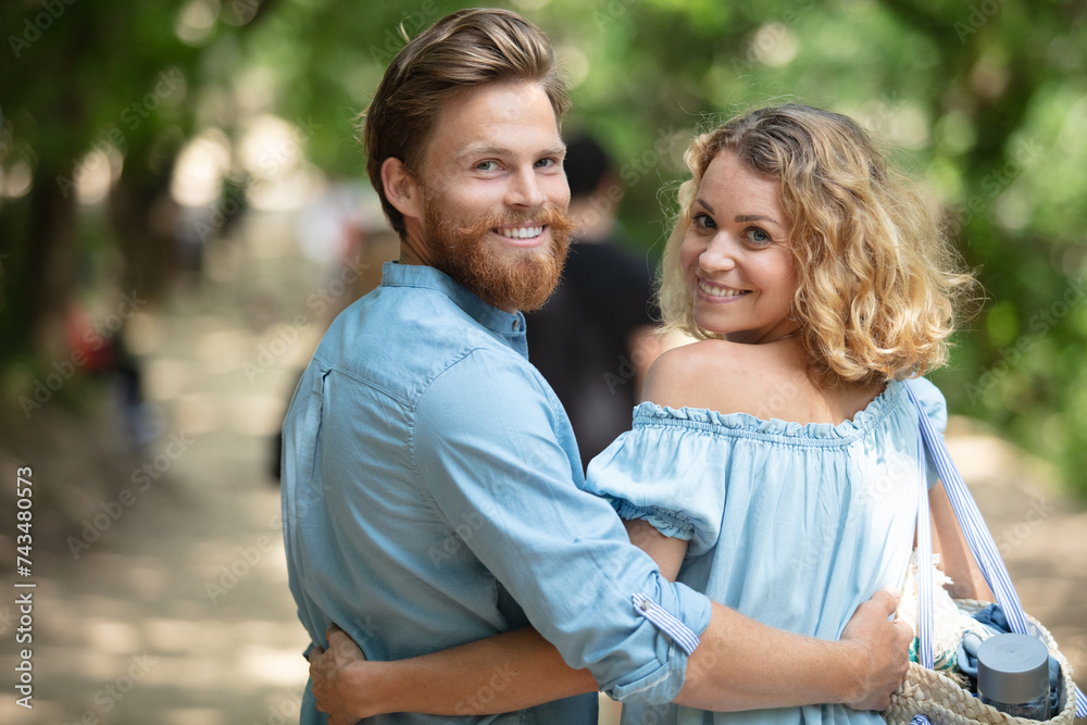 Obraz premium back view of young couple walking in park