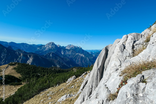 Rock formation with panoramic view of majestic mountain peaks of Gesäuse seen from Hochblaser in Eisenerz, Ennstal Alps, Styria, Austria. Idyllic hiking trail in Austrian Alps. Wanderlust in nature photo