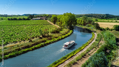 Houseboat in Canal du Midi aerial drone view from above, family water travel by boat, vacation in Southern France
