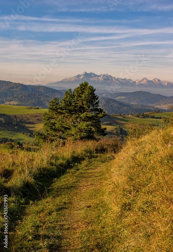 Dirt road in autumn landscape with a view of the Tatras, Pieniny Mountains, Autumn in Pieniny mountains, nice rural landscape in the hills. Landscape of Polish mountains on a warm and sunny day.