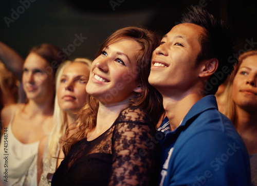 Music, night and crowd with couple at concert for band, happiness and festival date together. Fans, support and social with group of people at musician event for audience, performance and song