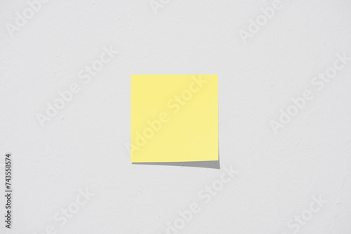 Yellow sticky note on white wall