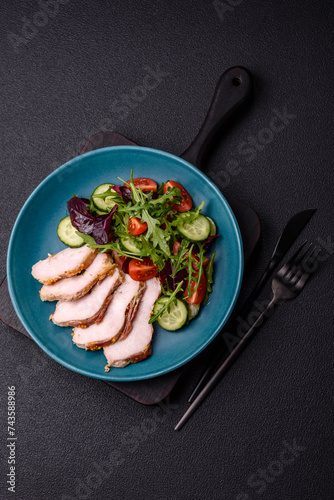 Delicious dietary salad with arugula, cucumber and cherry tomatoes and chicken breast slices