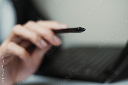 Hand of professional man pointing to the camera using stylus photo