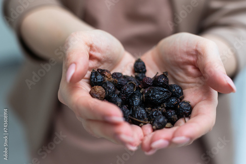 Woman holding a dried rose hips close up