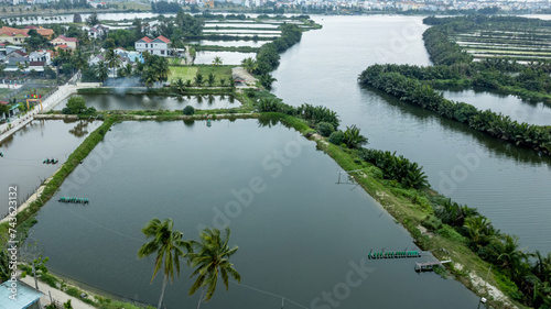 Aerial view of lush green tropical river landscape with aquaculture farms, ideal for environmental backgrounds with space for text, Earth day concept