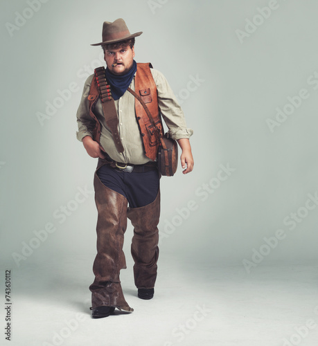Portrait, serious and criminal cowboy in studio mockup, outlaw and wild west character with pistol. Overweight texas man, bandit face or gun belt for fighting, western or cigar by white background photo