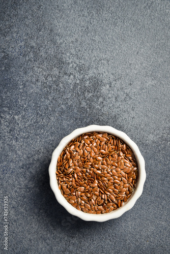 Close-up of flax seeds in a ceramic bowl. Superfood On a dark concrete background.