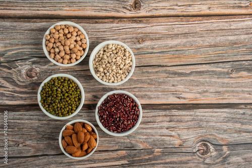 Mung beans, Red kidney beans, Chickpeas source and peeled barley in white cup on spoon wooden on wood background