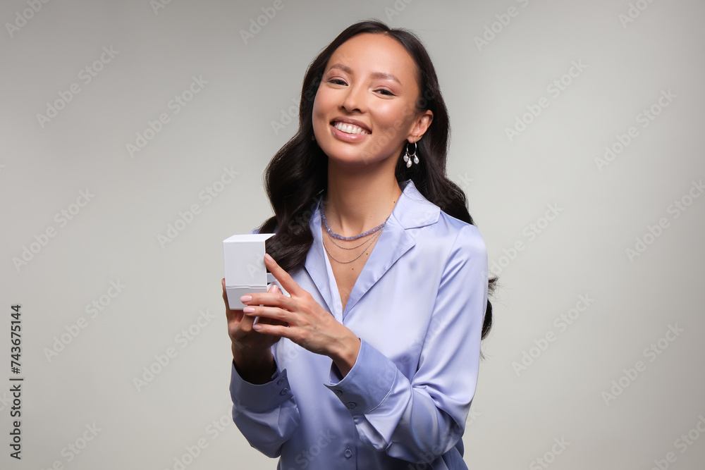 Close up portrait of a beautiful elegant asia woman with white box stylish jewelry on a white background. Asian cute girl in light blue dress. Beautiful girl with jewelry. Close up portrait of a beautiful elegant asia woman with white box stylish jewelry on a white background. Asian cute girl in light blue dress. Beautiful girl with jewelry.