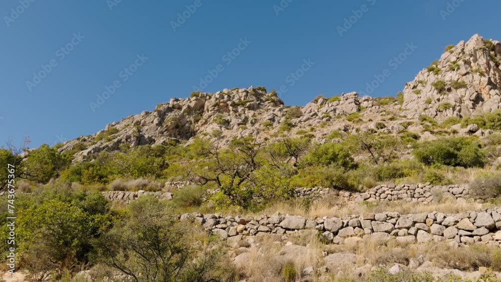 Cliffs and hills on a sunny day in Spain. A popular place for active walks in the park near Magdolena. Stone terraces to protect the gardens from erosion. Province of Costallon