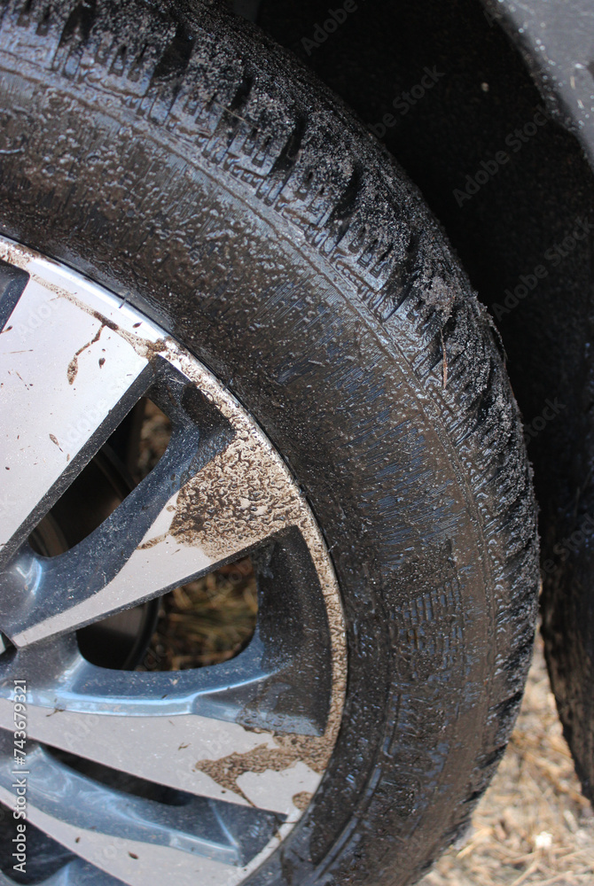 The wheel of the car is splashed with mud after an off road trip
