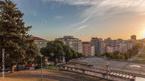 Panorama showing sunset over lawn at Alameda Dom Afonso Henriques and the Luminous Fountain aerial timelapse in Lisbon.