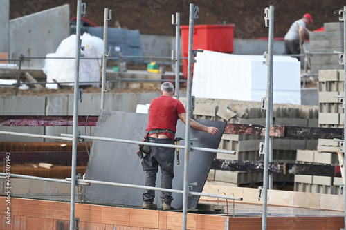 ouvrier montant un échaffaudage sur un chantier de construction photo