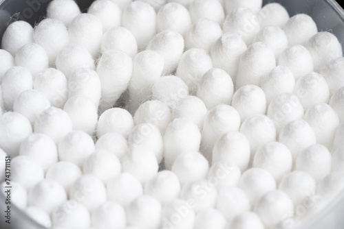 Macro view of white cotton ear cleaning buds arranged in black backgroud nicely in a container