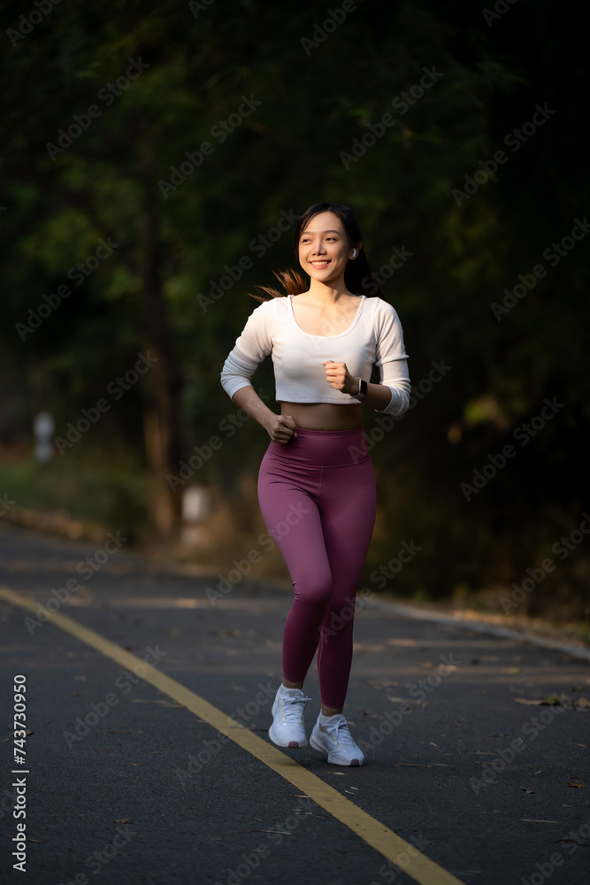 Cheerful woman enjoys jogging on the street in the warm morning sun. Cheerful woman enjoys jogging on the street in the warm morning sun.