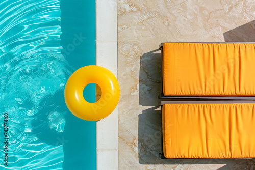 Top view swimming pool with yellow chaise lounge and swimming ring. Summer vacation concept