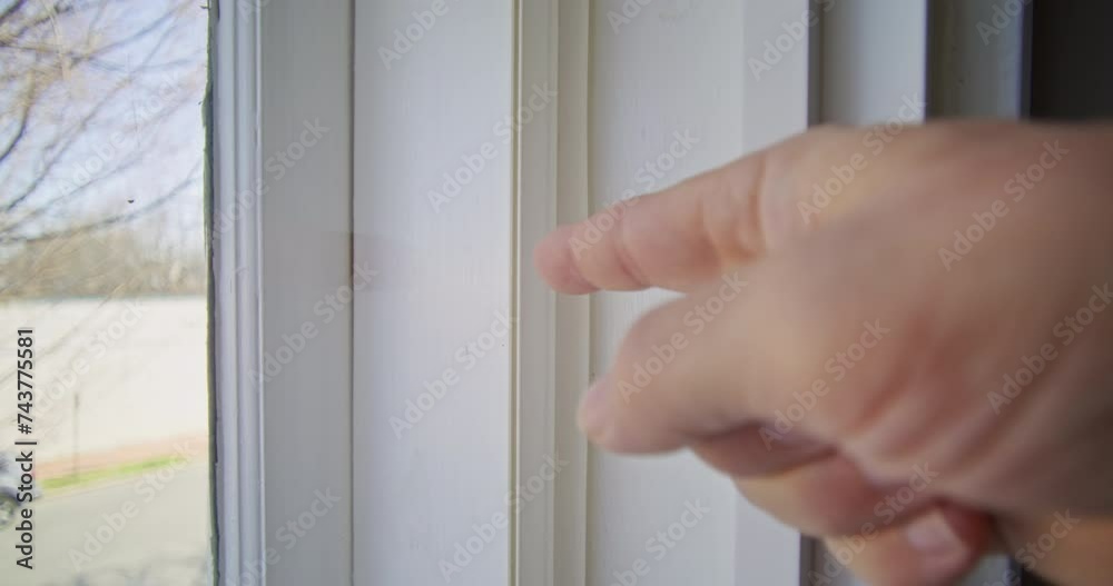Finger pointing at a window frame inside of a house Finger pointing at a window frame inside of a house