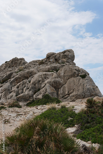 Rocks on the coast. Rocks on the mountain near vegetation. Sunny weather with a blue sky. Alcudia, Majorca.  photo