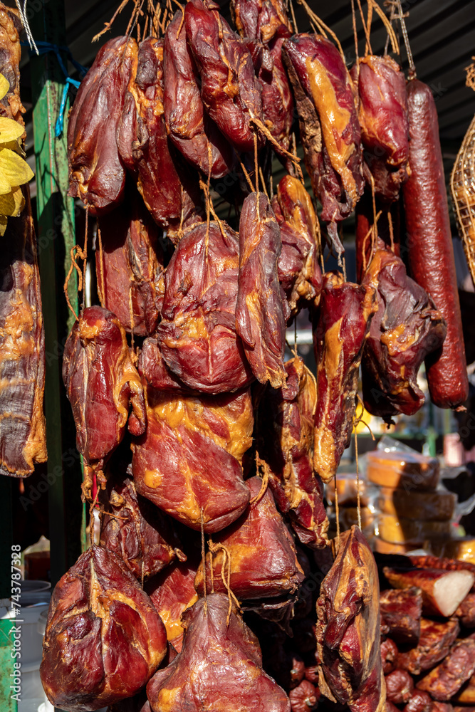 Delicious pieces of smoked meat exposed for sale in the market  presented for sale on a farmer's market in Kacarevo village, gastro bacon and dry meat products festival called Slaninijada (bacon)