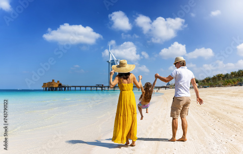 Obraz na płótnie A happy family on summer vacation walks down a beautiful city beach in Dubai, UAE w salonie