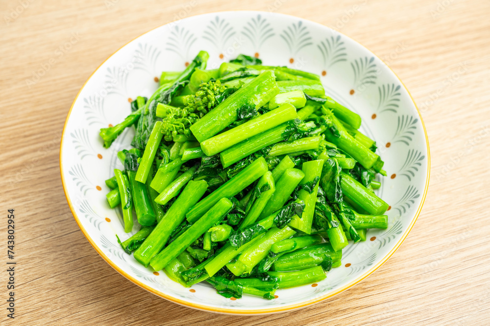 A plate of vegetarian vegetables with fried rapeseed on the table A plate of vegetarian vegetables with fried rapeseed on the table