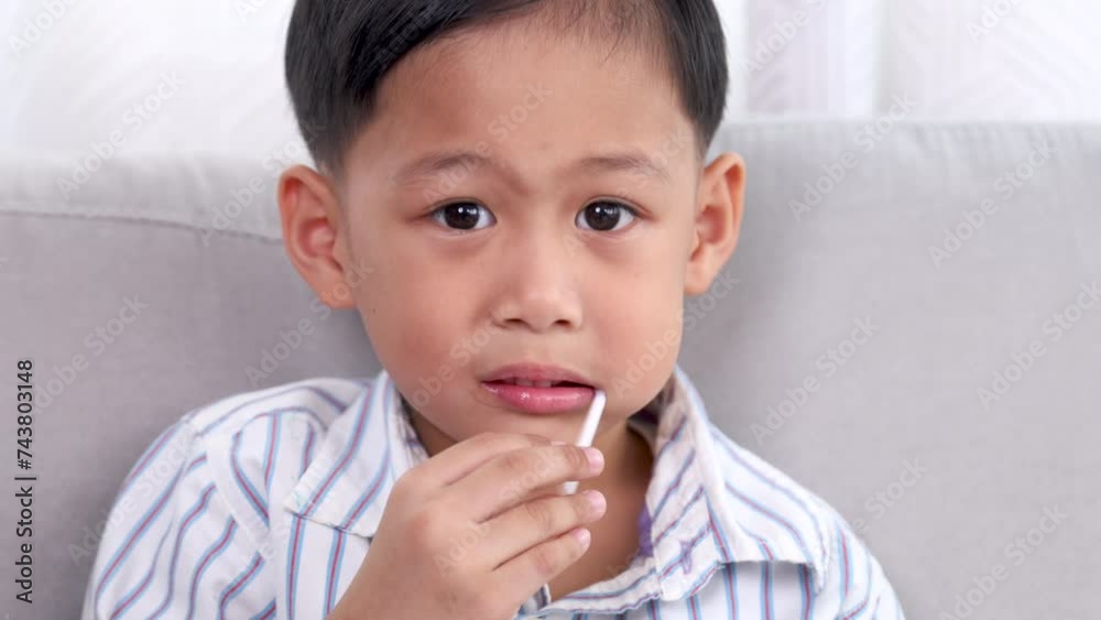 Asian cheerful boy holds a lollipop in his mouth, his bright smile hinting at a playful day with treats. grinning child enjoys a sweet lollipop, enjoy carefree weekend, dental care for kids concept Asian cheerful boy holds a lollipop in his mouth, his bright smile hinting at a playful day with treats. grinning child enjoys a sweet lollipop, enjoy carefree weekend, dental care for kids concept