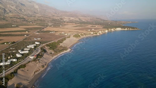 Aerial view of remote southern village in Crete Frangokastello with beautiful natural landscape, olive tree groves and villas, Orthi Ammos cliffs and beach photo