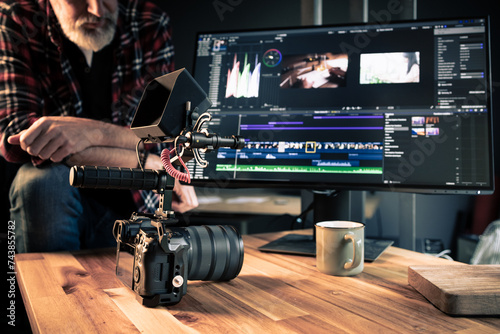 Photographe vidéaste créatif devant un ordinateur en train de faire du montage et de la post-production dans un studio photo