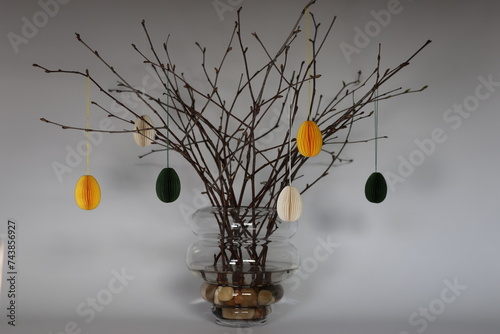 Easter Decoration. Green, yellow and white paper eggs hanging from beautiful naturally thin branches from birch. In Sweden it is often used as an Easter decoration.