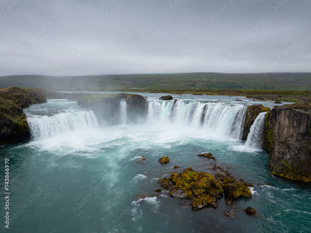 Fantastic shot of the Godafoss waterfall in Iceland and its incredible surroundings, aerial view. Tourist attraction and natural beauty concepts.