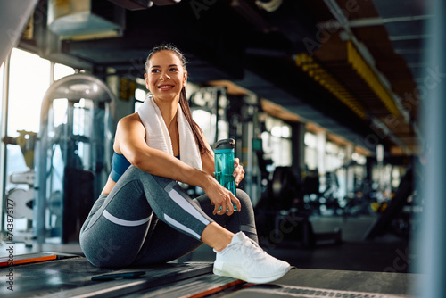 Fototapeta Naklejka Na Ścianę i Meble -  Young happy sportswoman having a water break while exercising in gym.