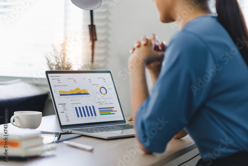 Fotografie Businesswoman or accountant analyzing data charts, graphs, and dashboard on laptop screen to increase sales and revenue