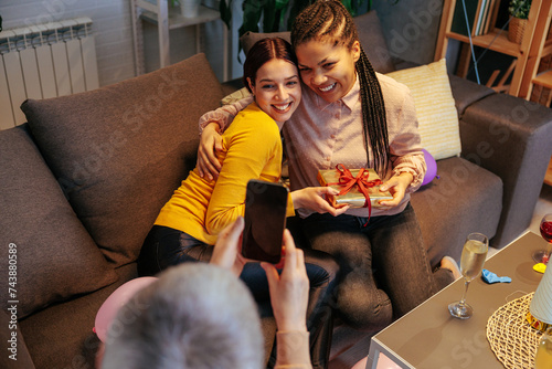 Mother takes photo of her daughter and her friend