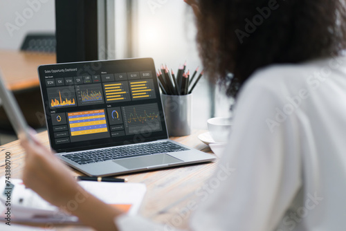 Female advisor financial business analytics using data dashboard graphs, charts, metrics, and KPI to analyze business performance.