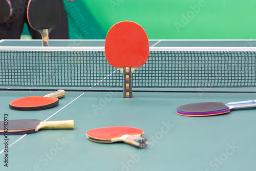 Ping pong rackets on the green table with net