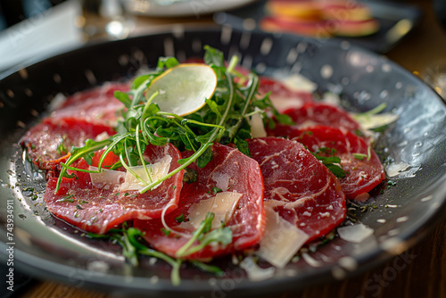 Beef carpaccio with herbs on a plate.