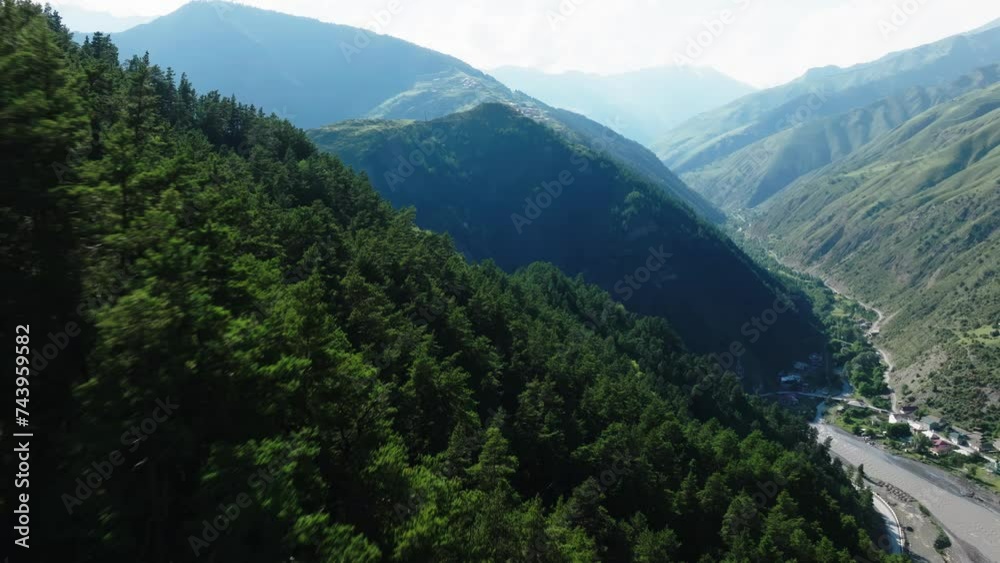 Aerial View Capturing the Contrast of Sunlit Green Mountainsides and Shadowed Valleys with Winding River Aerial View Capturing the Contrast of Sunlit Green Mountainsides and Shadowed Valleys with Winding River