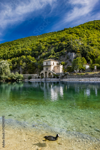 The enchanting Lake Scanno, in Abruzzo, in the province of L'Aquila, located between the Marsican Mountains. The small Church of Santa Maria dell'Annunziata overlooks the waters of the lake. photo