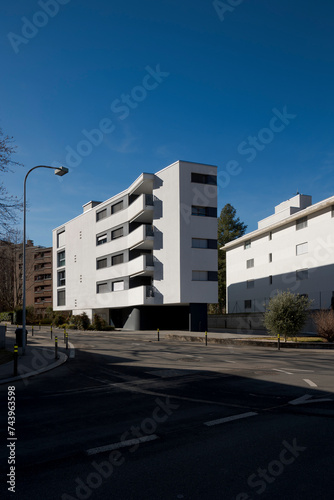 Modern condominium painted white with very particular protruding balconies. Residential neighborhood in Switzerland.