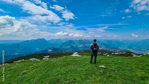 Hiker woman on top of mount Kriznik, Carinthia, border Austria Slovenia. Alpine meadow with scenic view of mountain range Karawanks, Slovenian Austrian Alps. Hiking trail Petzen, Bleiburg, Völkermarkt photo