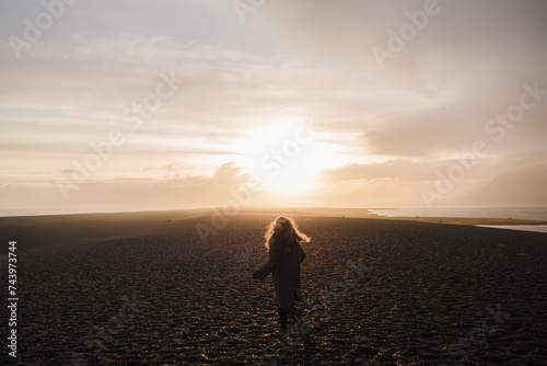 Traveling and exploring Iceland landscapes and travel destinations. Young traveler enjoying the view of beautiful nature. Female tourist watching spectacular scenery. Summer tourism by Atlantic ocean