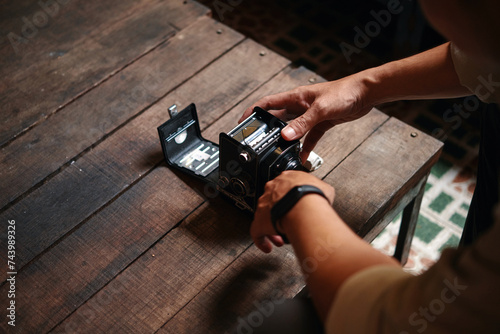 Closeup image of photographer swapping film in old camera photo
