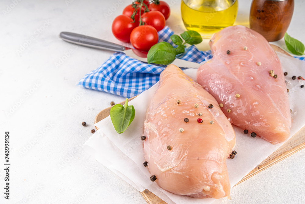 Raw uncooked chicken breast fillet on kitchen table with spices. White lean meat cooking background, white table copy space Raw uncooked chicken breast fillet on kitchen table with spices. White lean meat cooking background, white table copy space