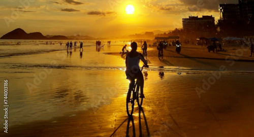 Beach sunset with a bike in the foreground and people in the background